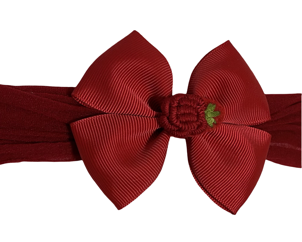 Red headband with a large bow and small flower on a white background