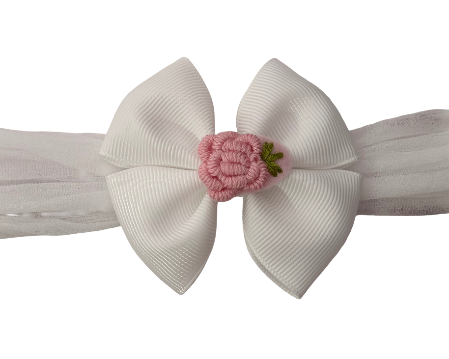 White headband with a large bow and pink flower on a white background