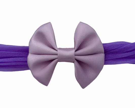 Purple headband with a large bow on a white background