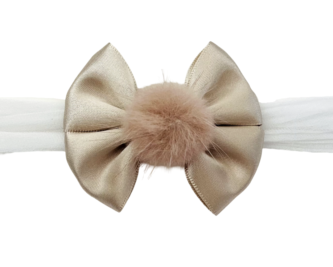 Beige bow headband with a fluffy center on a white background
