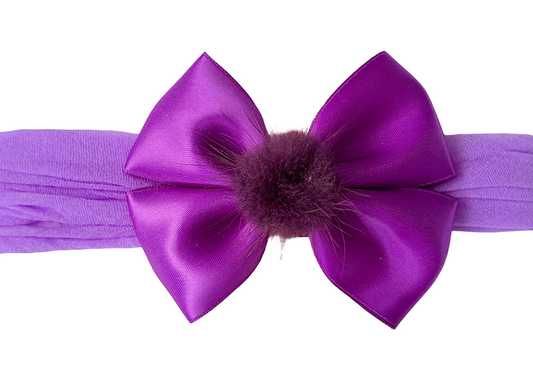Purple headband with a large bow and fur center on a white background