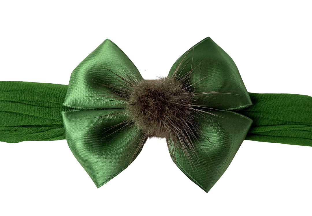 Green headband with a large bow and fur center on a white background