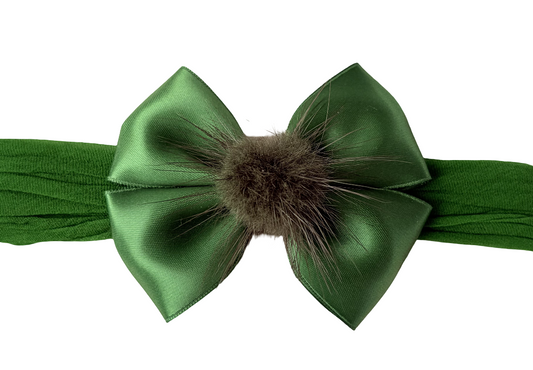 Green headband with a large bow and fur center on a white background