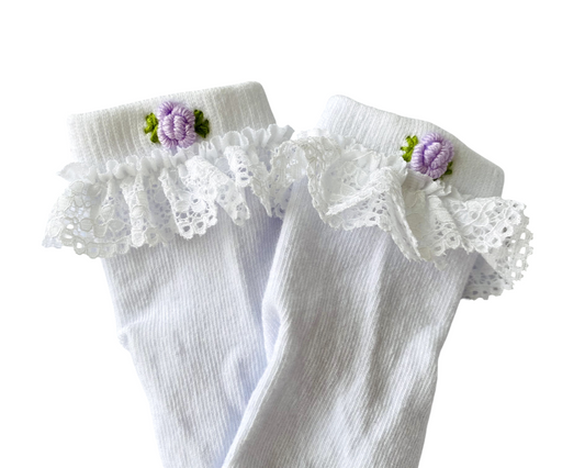 White socks with lace and floral details on a white background