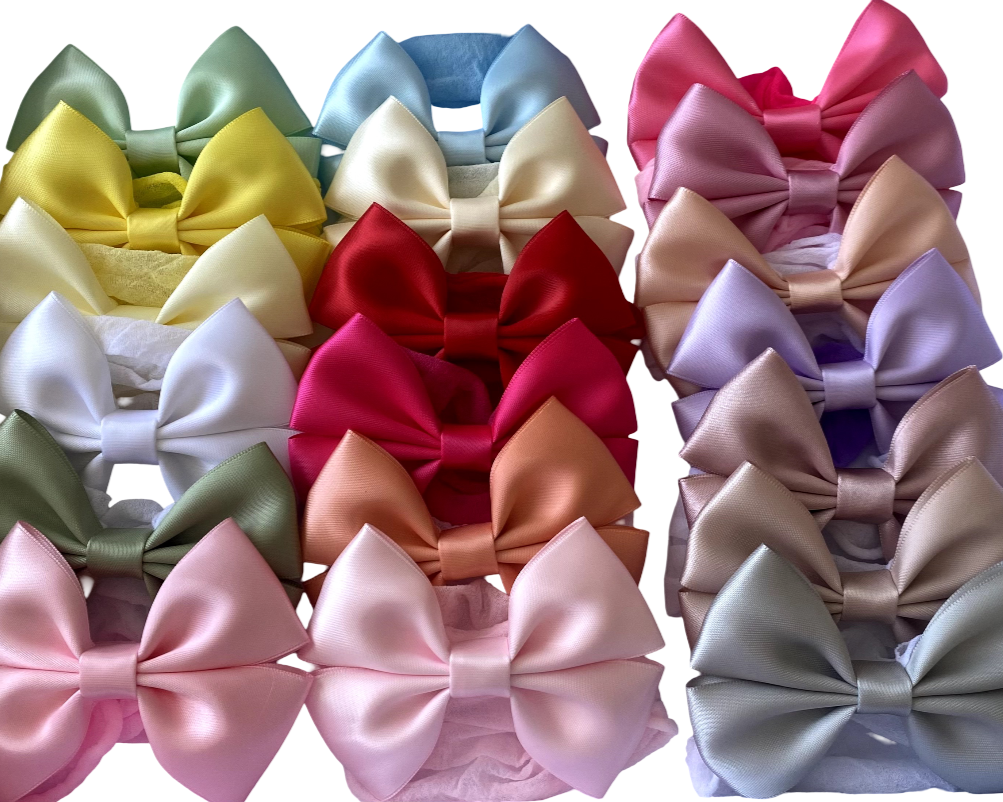 Collection of colorful satin hair bows arranged in a grid on a white background