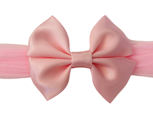 Pink bow headband on a white background