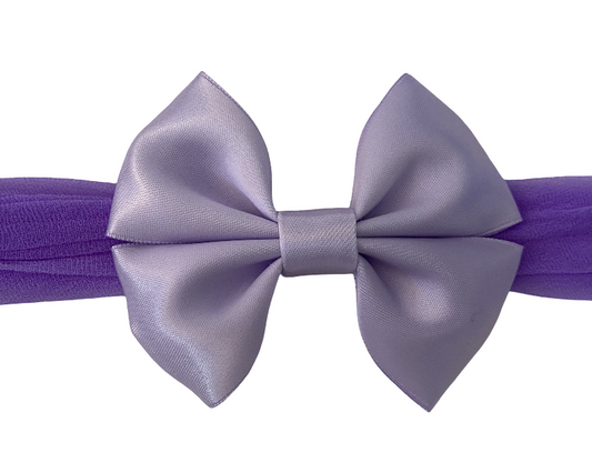 Purple headband with a large bow on a white background