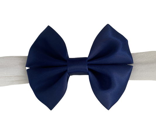 Navy blue bow on a white headband with a white background