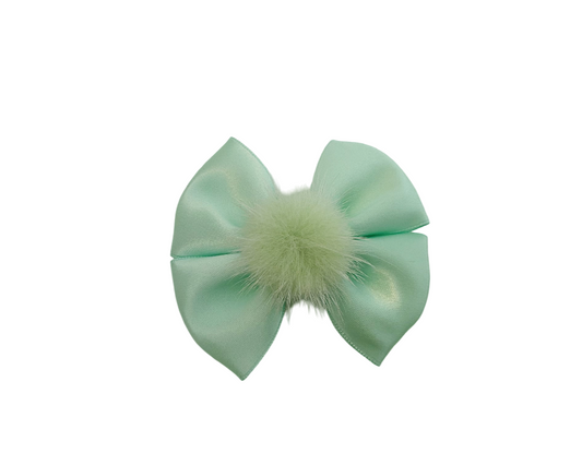 Mint green bow with a fluffy center on a white background