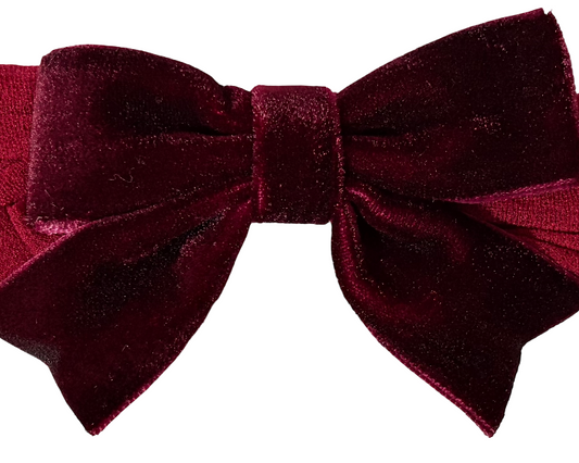 Red velvet bow headband on a white background